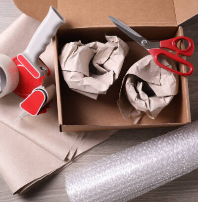 Boîte en carton ouverte contenant des matériaux d’emballage et outils de protection